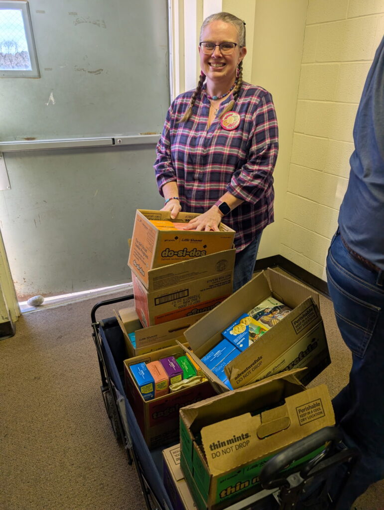 A picture of on of our flute players with a wagon full of Girlscout Cookies